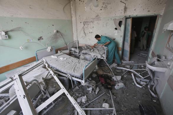 Palestinian medic inspects a damaged room at Al-Aqsa hospital, which witnesses said was damaged in Israeli shelling on Monday, in Deir El-Balah in the central Gaza Strip