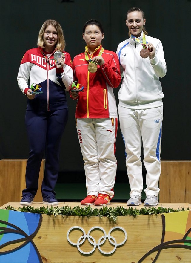 epa05461369 Zhang Mengxue (C) of China poses with her gold medal on the podium after winning the women's 10m Air Pistol final of the Rio 2016 Olympic Games Shooting events at the Olympic Shooting Centre in Rio de Janeiro, Brazil, 07 August 2016. Zhang Mengxue won ahead of second placed Vitalina Batsarashkina (L) of Russia and third placed Anna Korakaki (R) of Greece. EPA/VALDRIN XHEMAJ